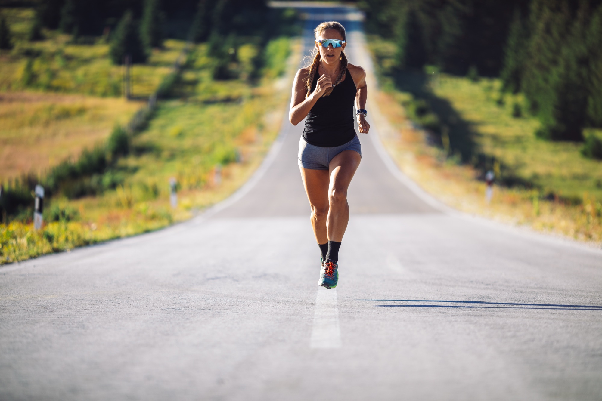 Endurance runner on an open road in bright daylight